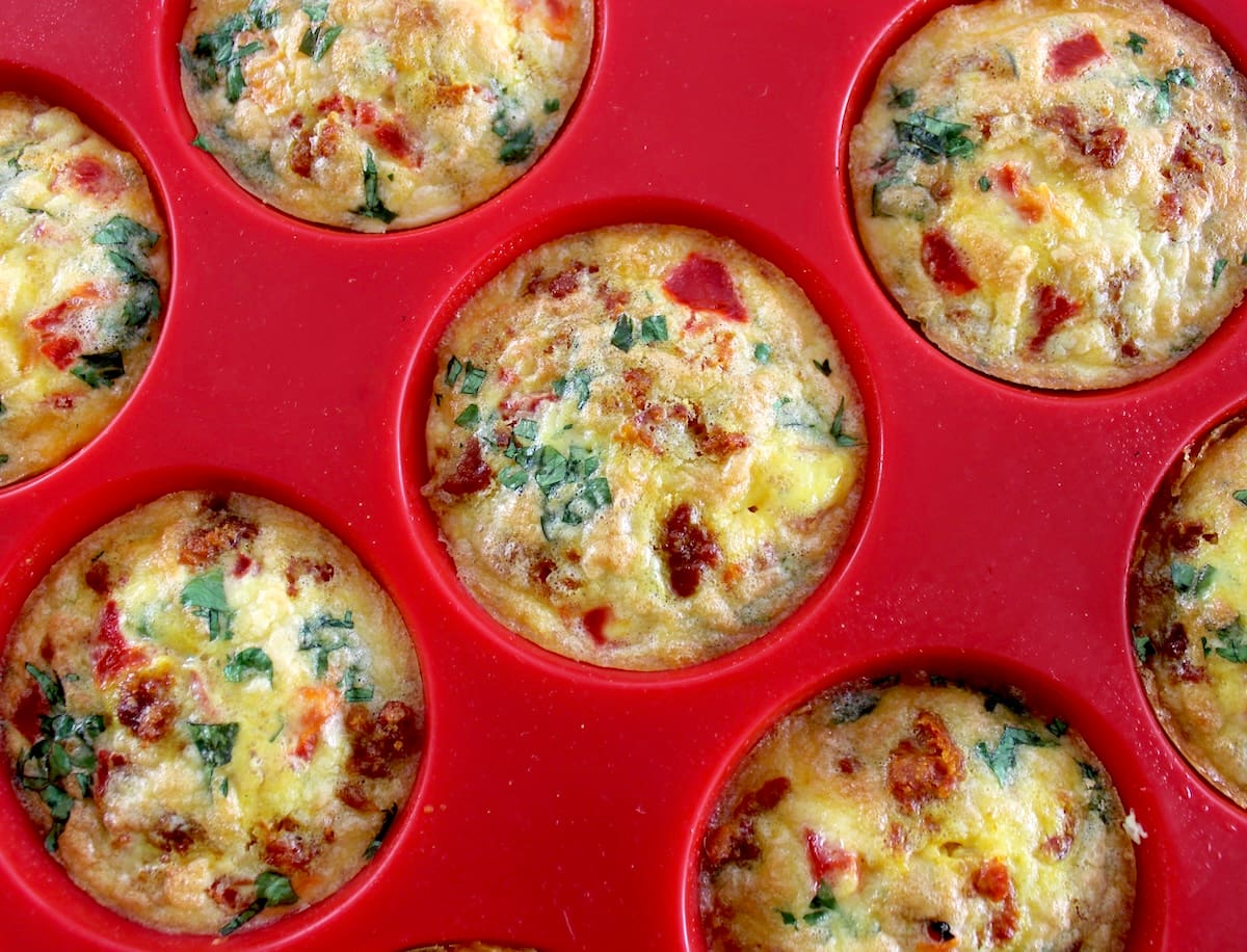 Chorizo and Pepper Egg Muffins in red muffin pan