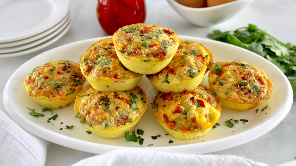 Chorizo and Pepper Egg Muffins stacked up on white oval platter