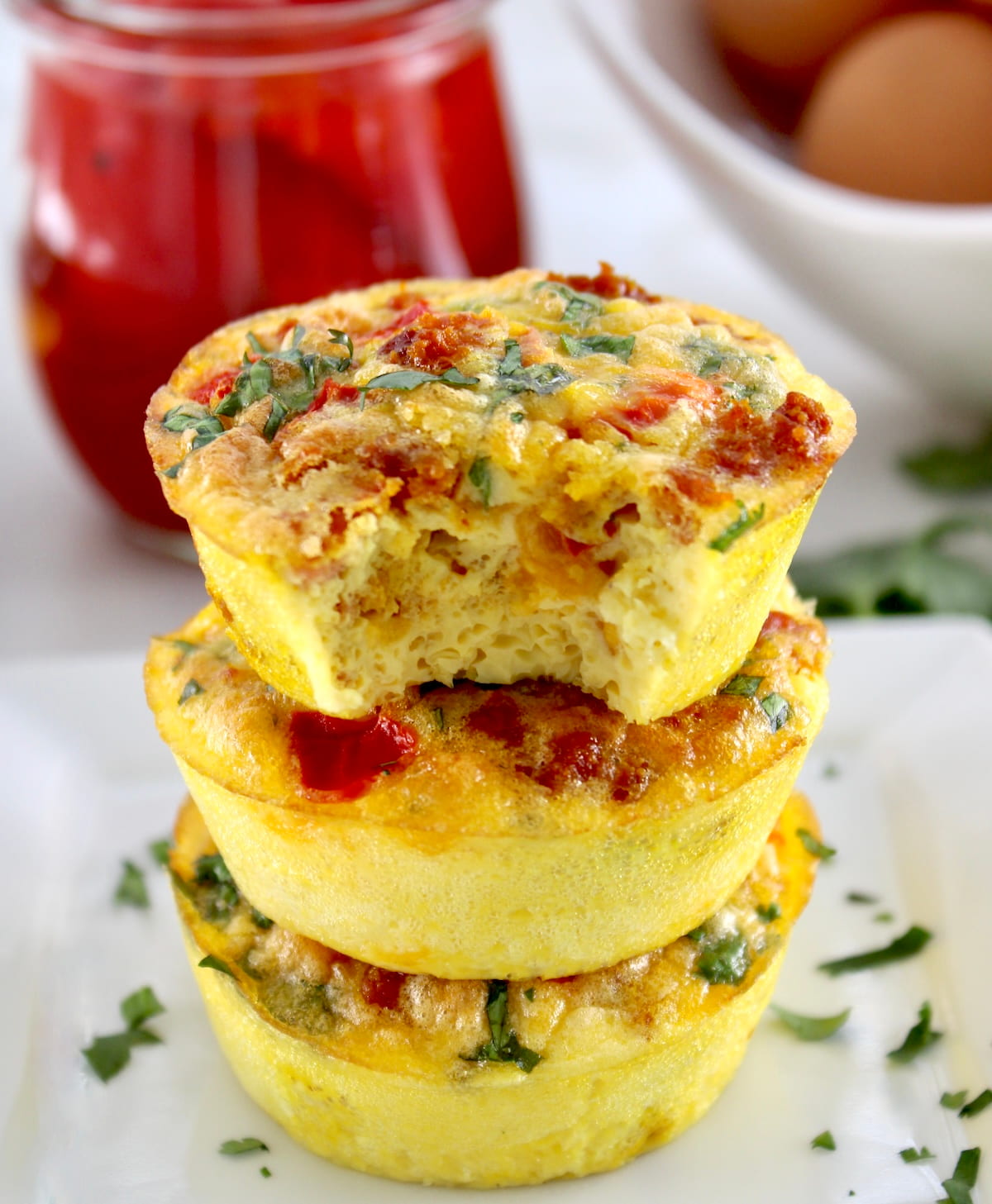 3 Chorizo and Pepper Egg Muffins stacked upon another with bite missing on top muffin