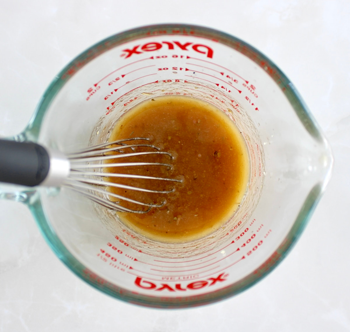 Grilled Chicken Margherita marinade in measuring cup with whisk