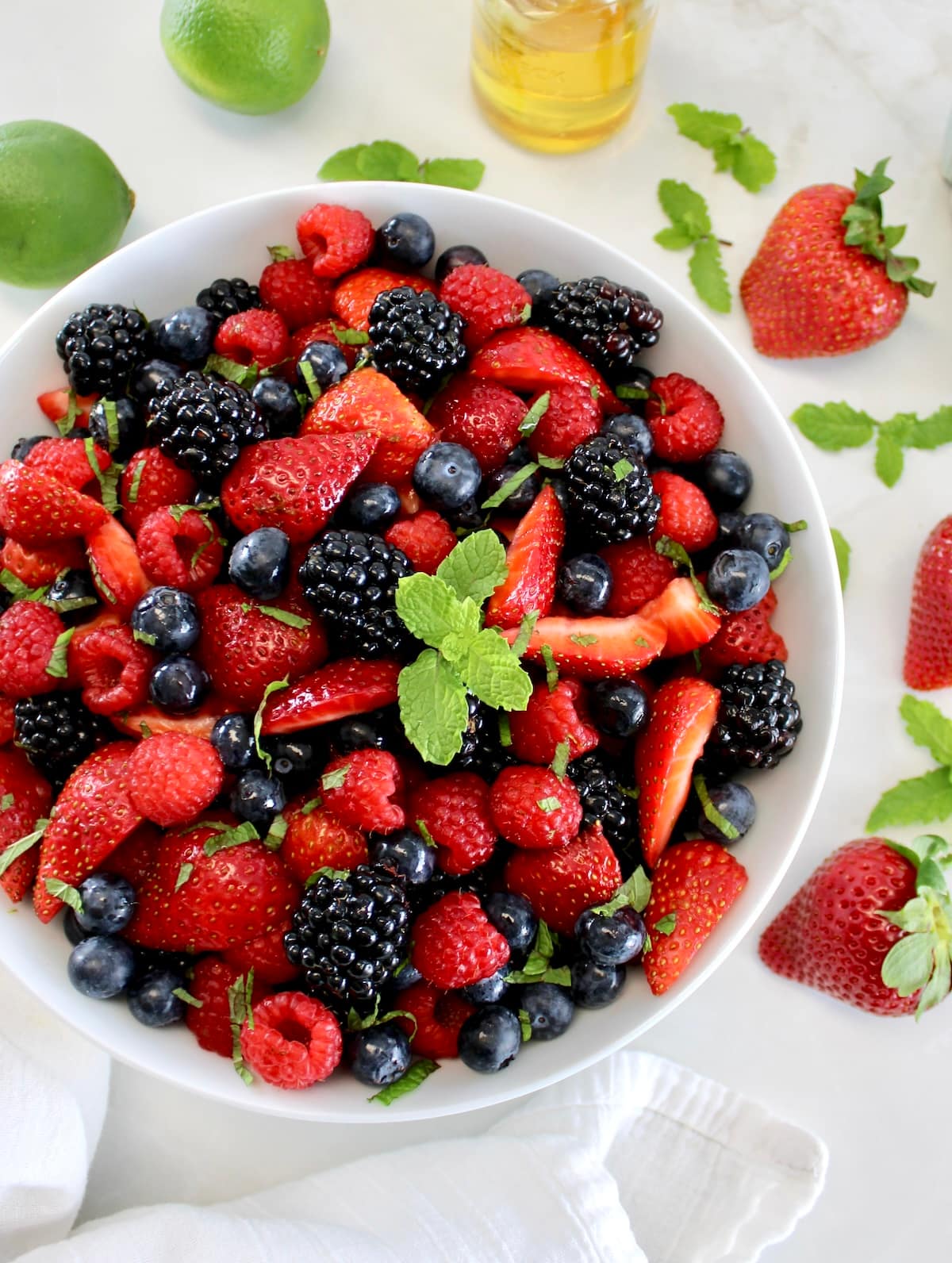 Keto Fruit Salad in white bowl with mint sprig on top 
