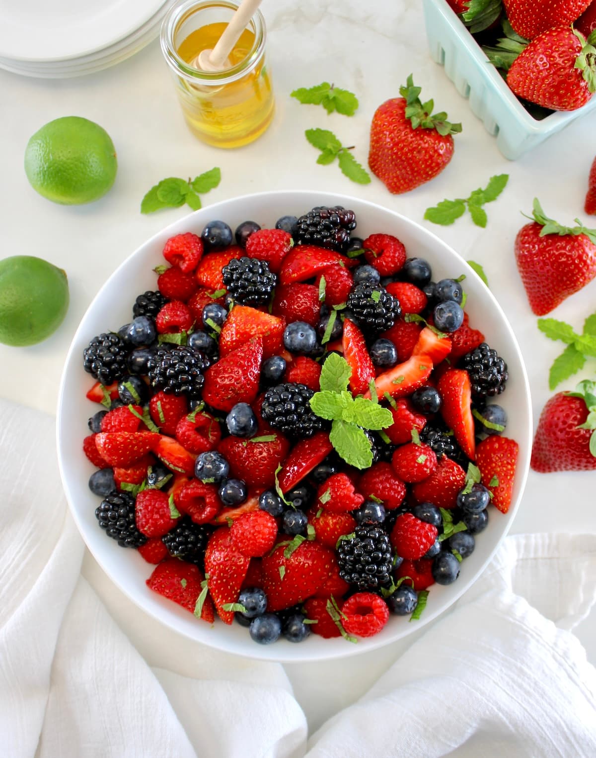 Keto Fruit Salad in white bowl with mint sprig on top