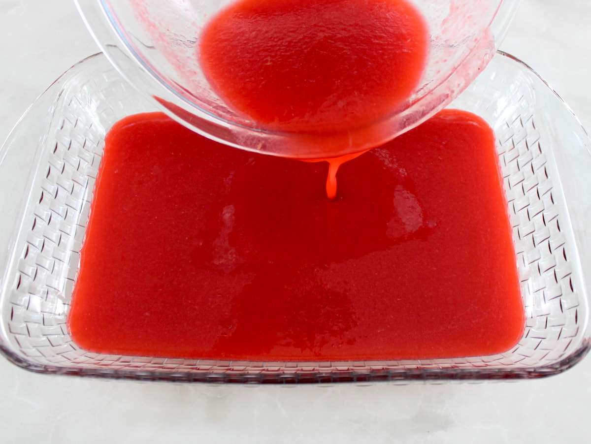 Raspberry Lemon Granita liquid pouring into glass casserole dish