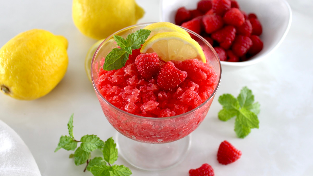 Raspberry Lemon Granita in glass with lemon slices and raspberries