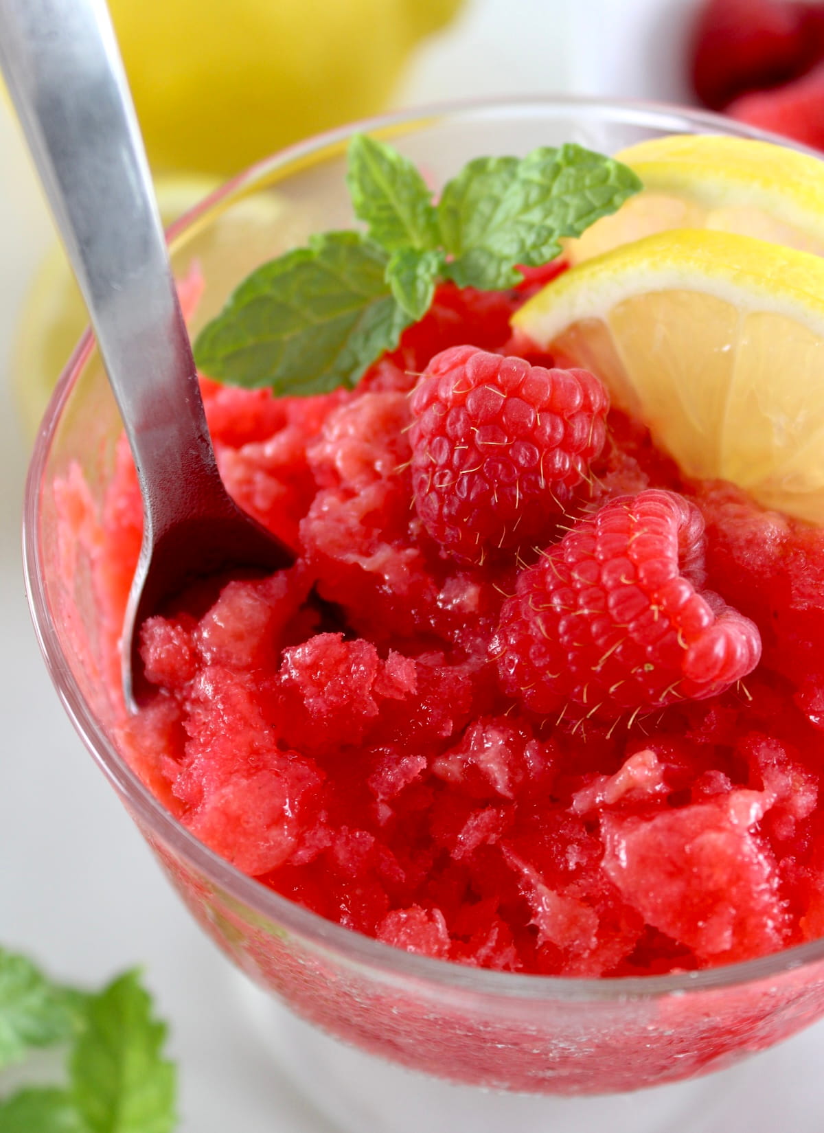 closeup of Raspberry Lemon Granita in glass with spoon dug in