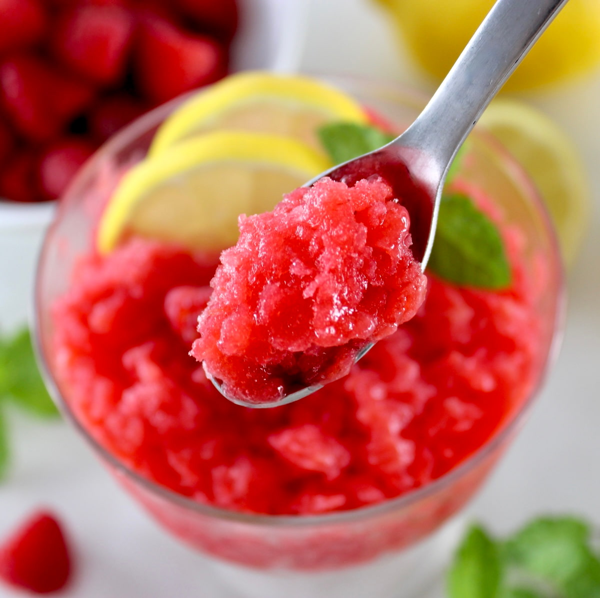 spoonful of Raspberry Lemon Granita held up over glass