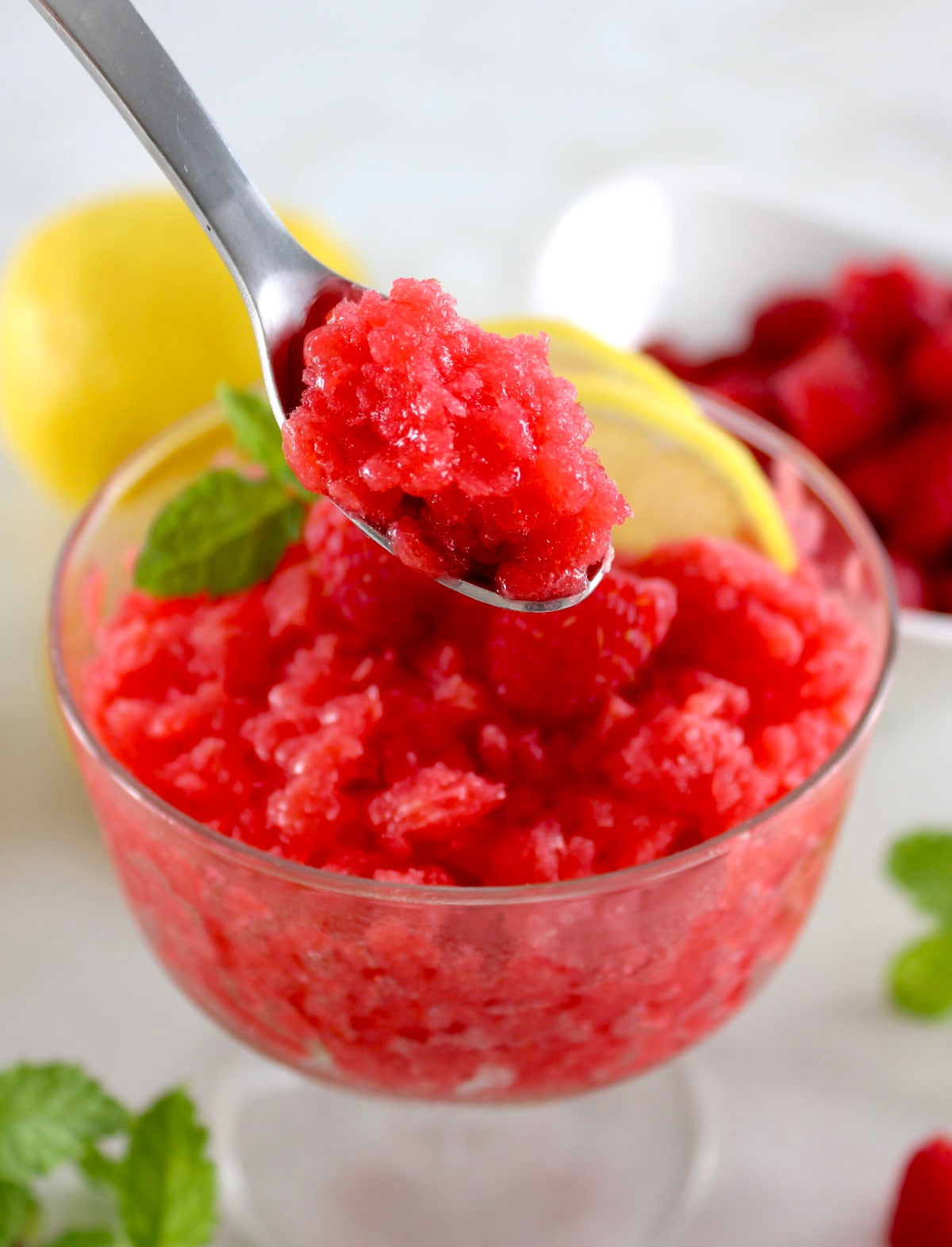 spoonful of Raspberry Lemon Granita held up over glass