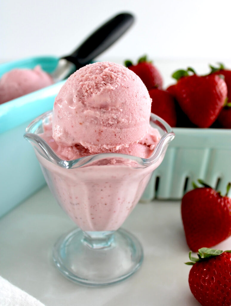 Strawberry Cottage Cheese Ice Cream in glass with strawberries in back