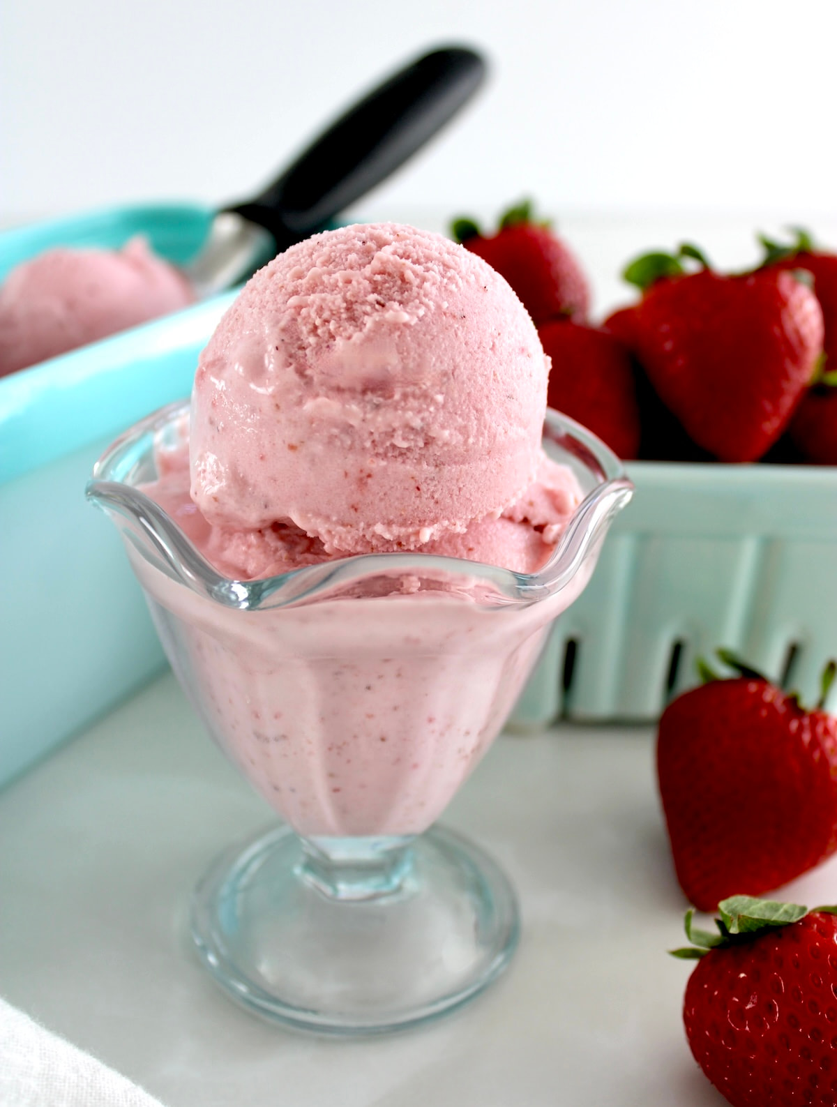 Strawberry Cottage Cheese Ice Cream in glass with strawberries in back