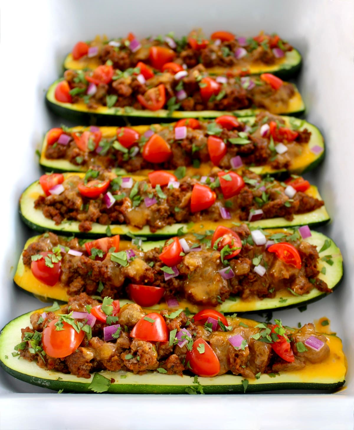  Taco Zucchini Boats lined up in white casserole dish