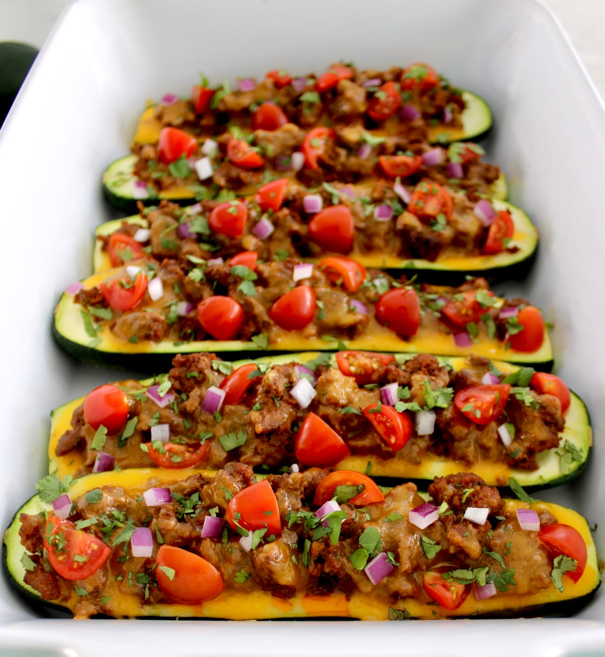 Taco Zucchini Boats lined up in white casserole dish