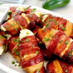 Air Fryer Bacon Wrapped Jalapeño Poppers on white plate with chopped parsley