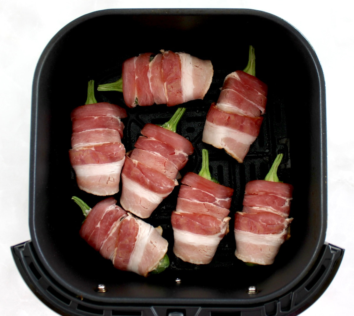 7 Air Fryer Bacon Wrapped Jalapeño Poppers unbaked in air fryer basket
