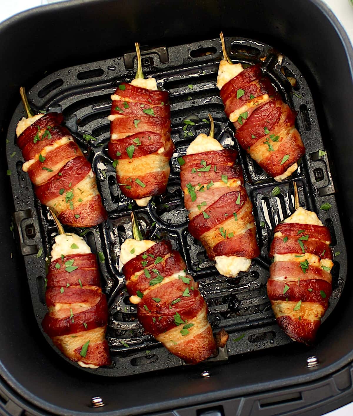 overhead view of Air Fryer Bacon Wrapped Jalapeño Poppers in air fryer basket