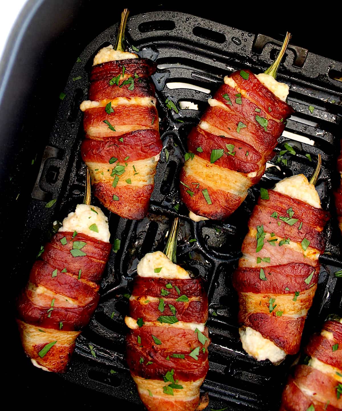 overhead view of Air Fryer Bacon Wrapped Jalapeño Poppers in air fryer basket