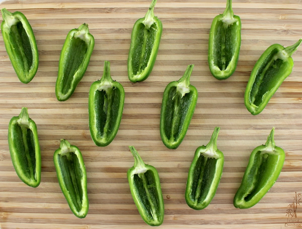 12 jalapeno halves scooped out on cutting board
