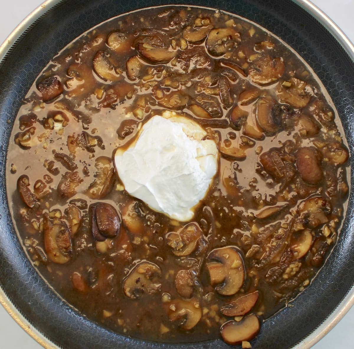 Chicken Stroganoff sauce with sour cream in center of skillet