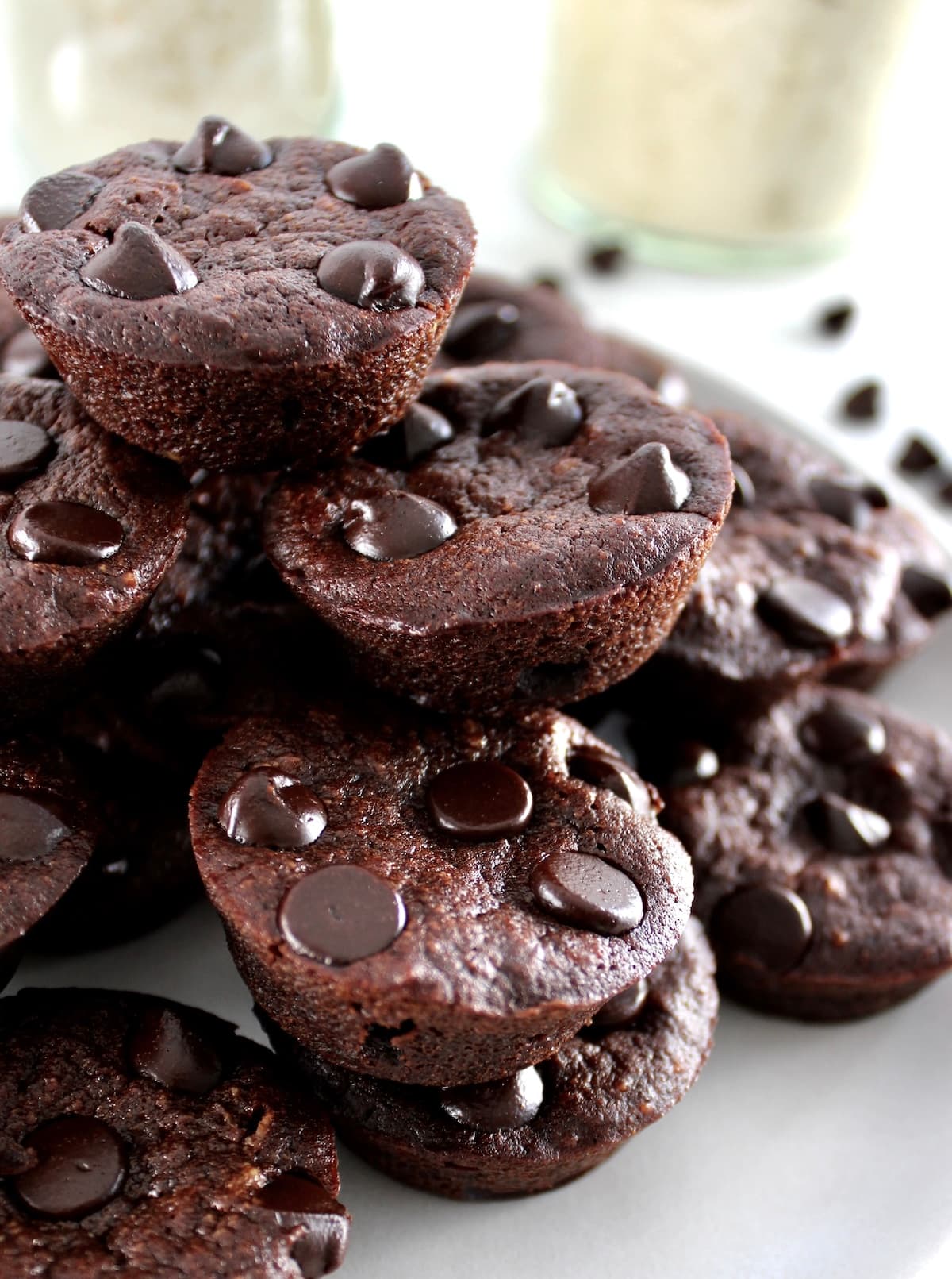 closeup of Chocolate Coconut Brownie Bites stacked up on white plate