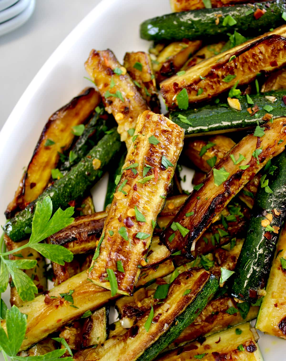 closeup of Easy Sautéed Zucchini in white platter with fresh parsley