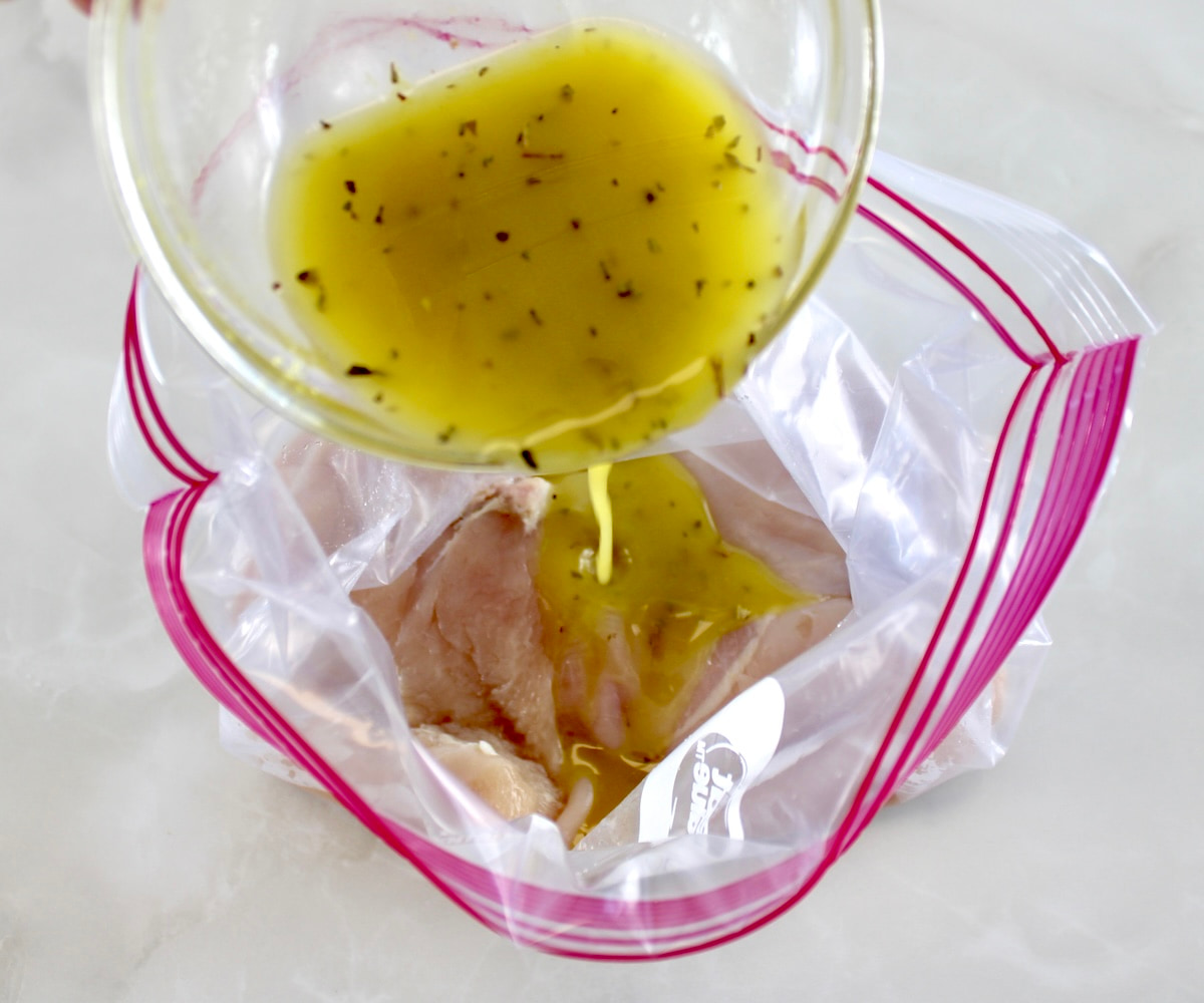 lemon chicken marinade pouring over chicken in food storage bag