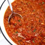 Italian Meat Sauce in white pan with silver serving spoon on side
