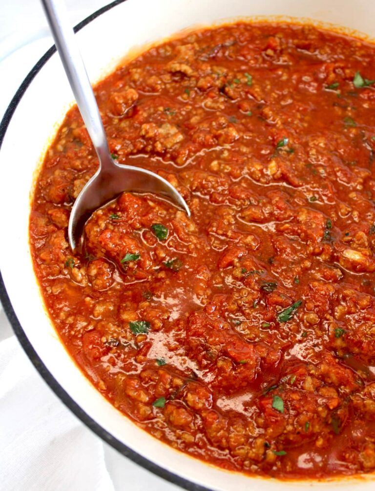 Italian Meat Sauce in white pan with silver serving spoon on side