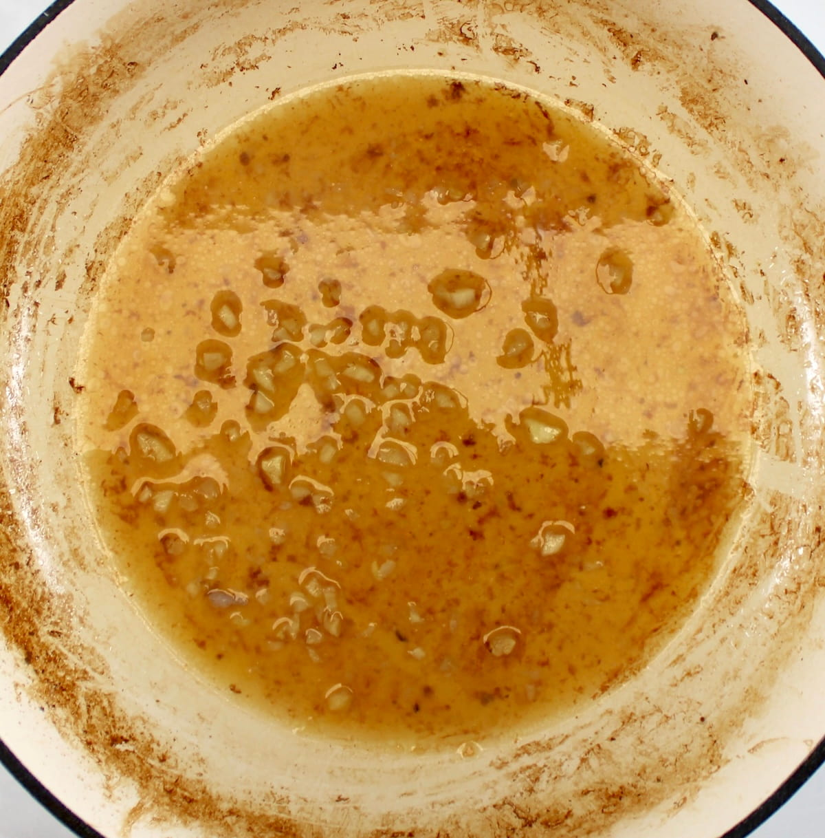 white wine deglazing pot with minced garlic