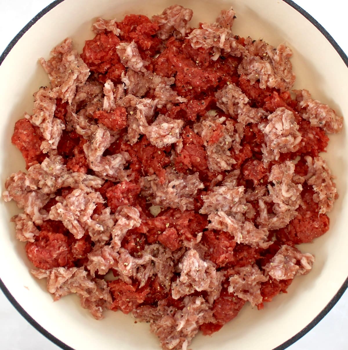 raw ground beef and italian sausage in pot