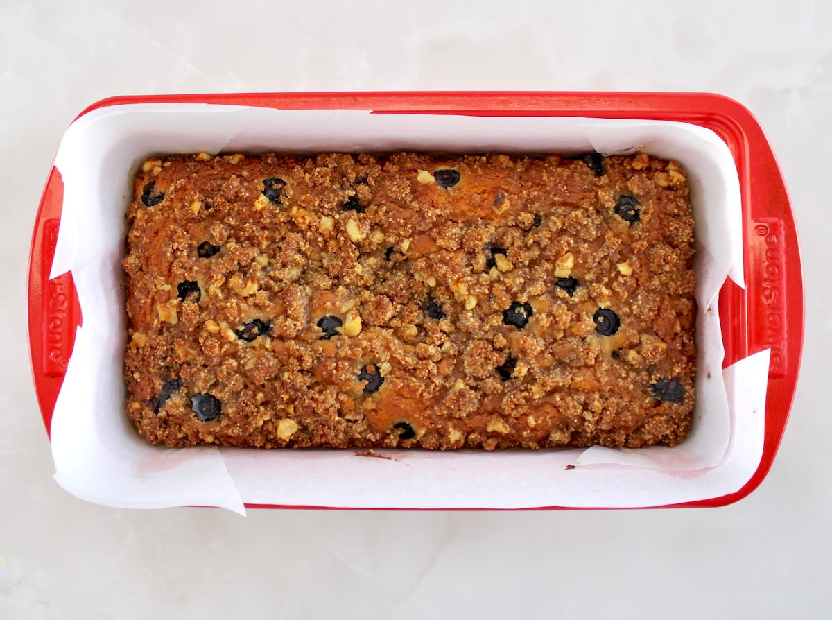 Keto Blueberry Crumb Loaf in red loaf pan with parchment paper