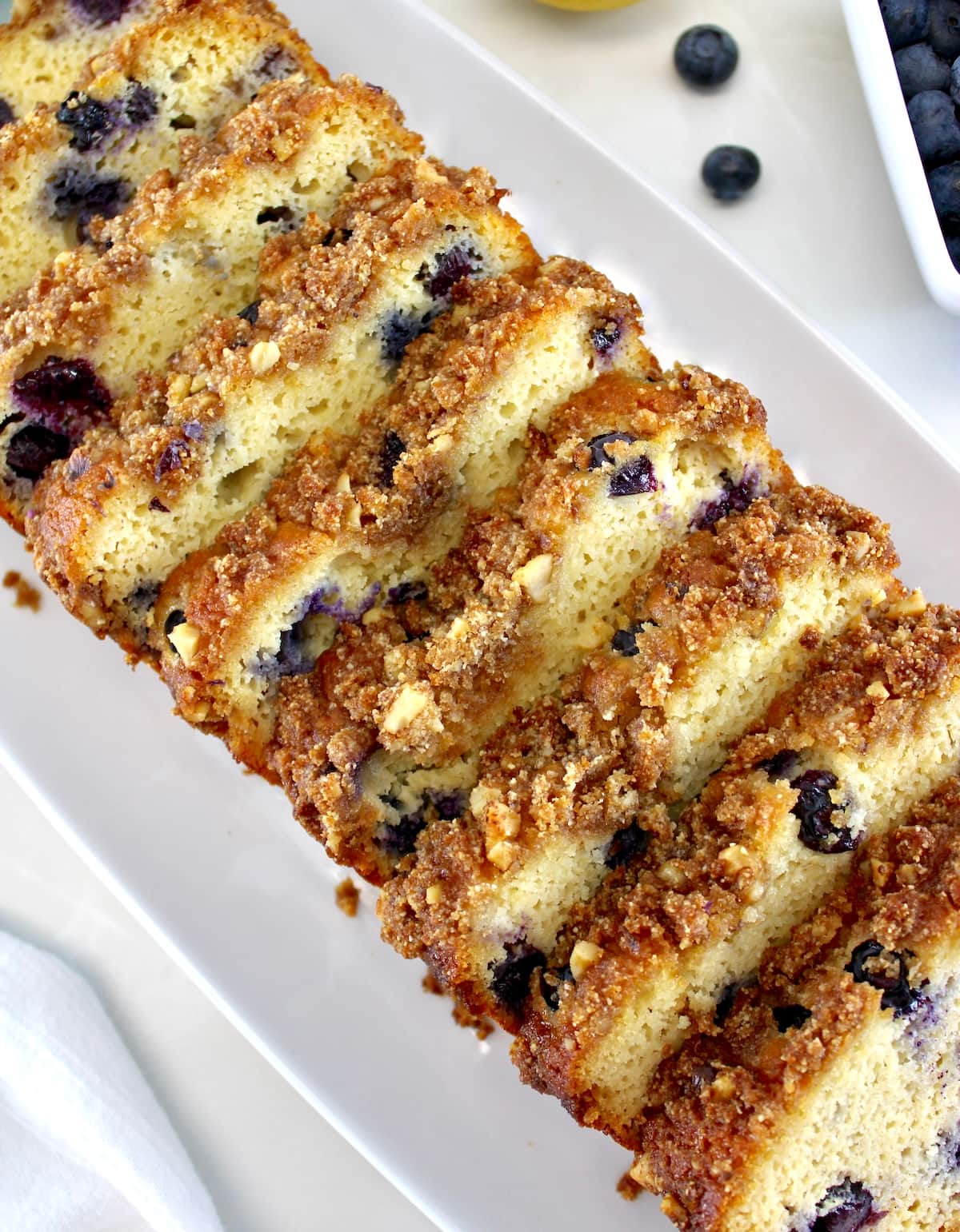 overhead closeup of Keto Blueberry Crumb Loaf sliced on white plate