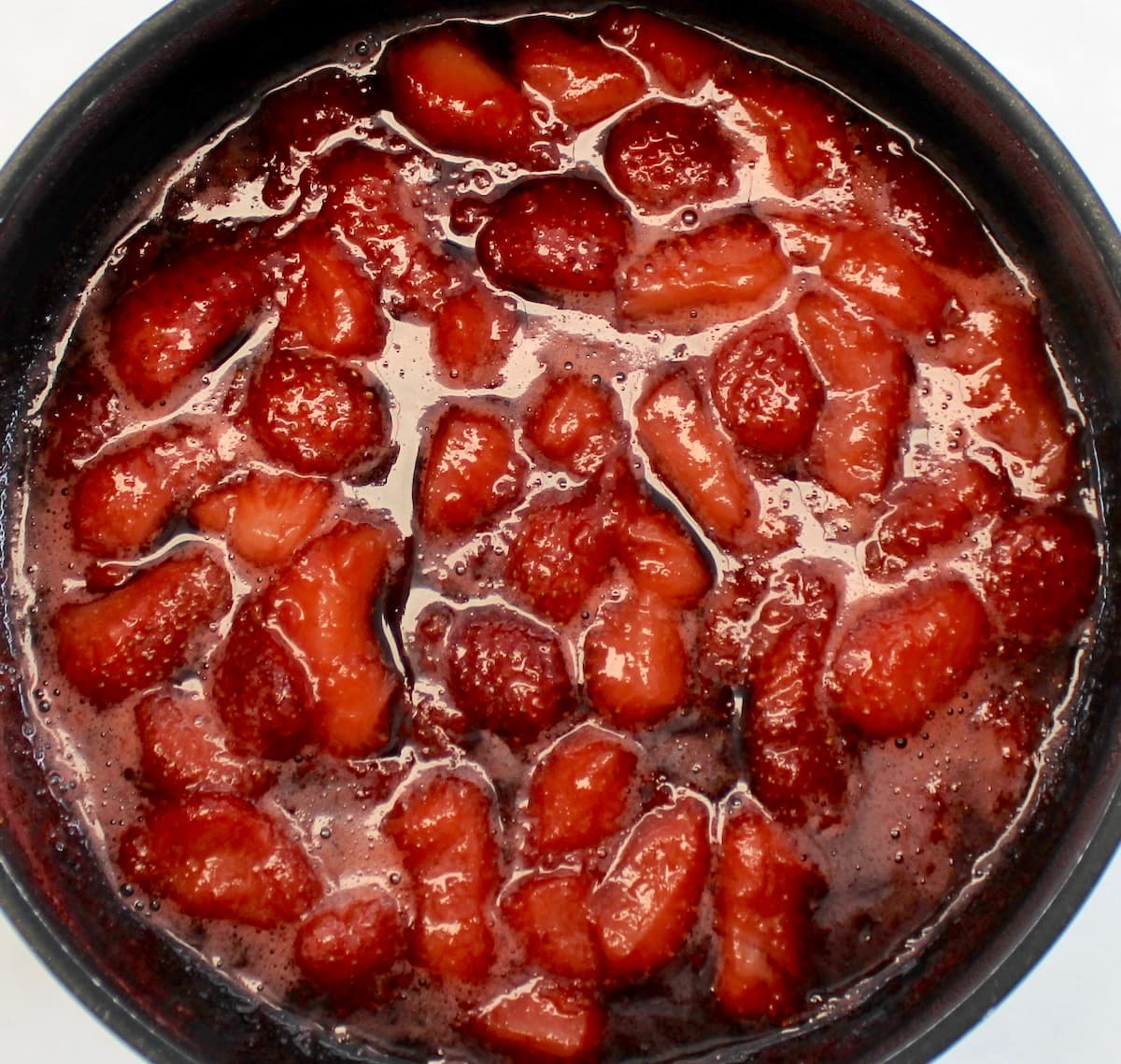 simmering cut up strawberries in saucepan