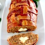 Bacon Wrapped Cheese Stuffed Italian Meatloaf on white plate with one slice