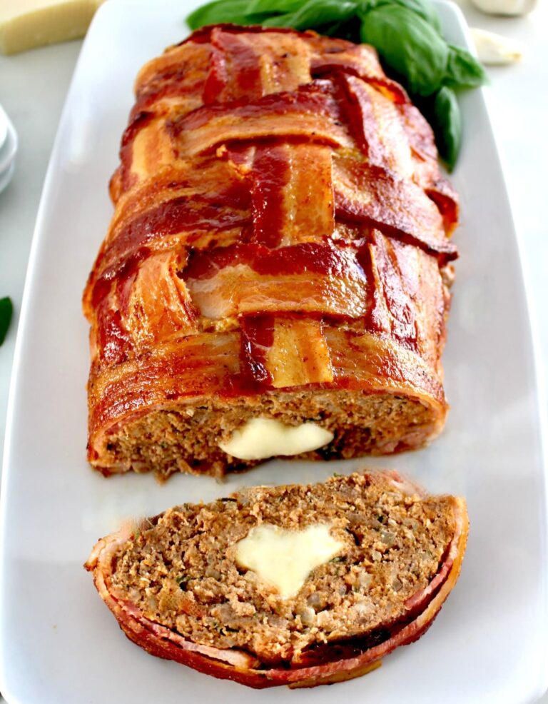 Bacon Wrapped Cheese Stuffed Italian Meatloaf on white plate with one slice
