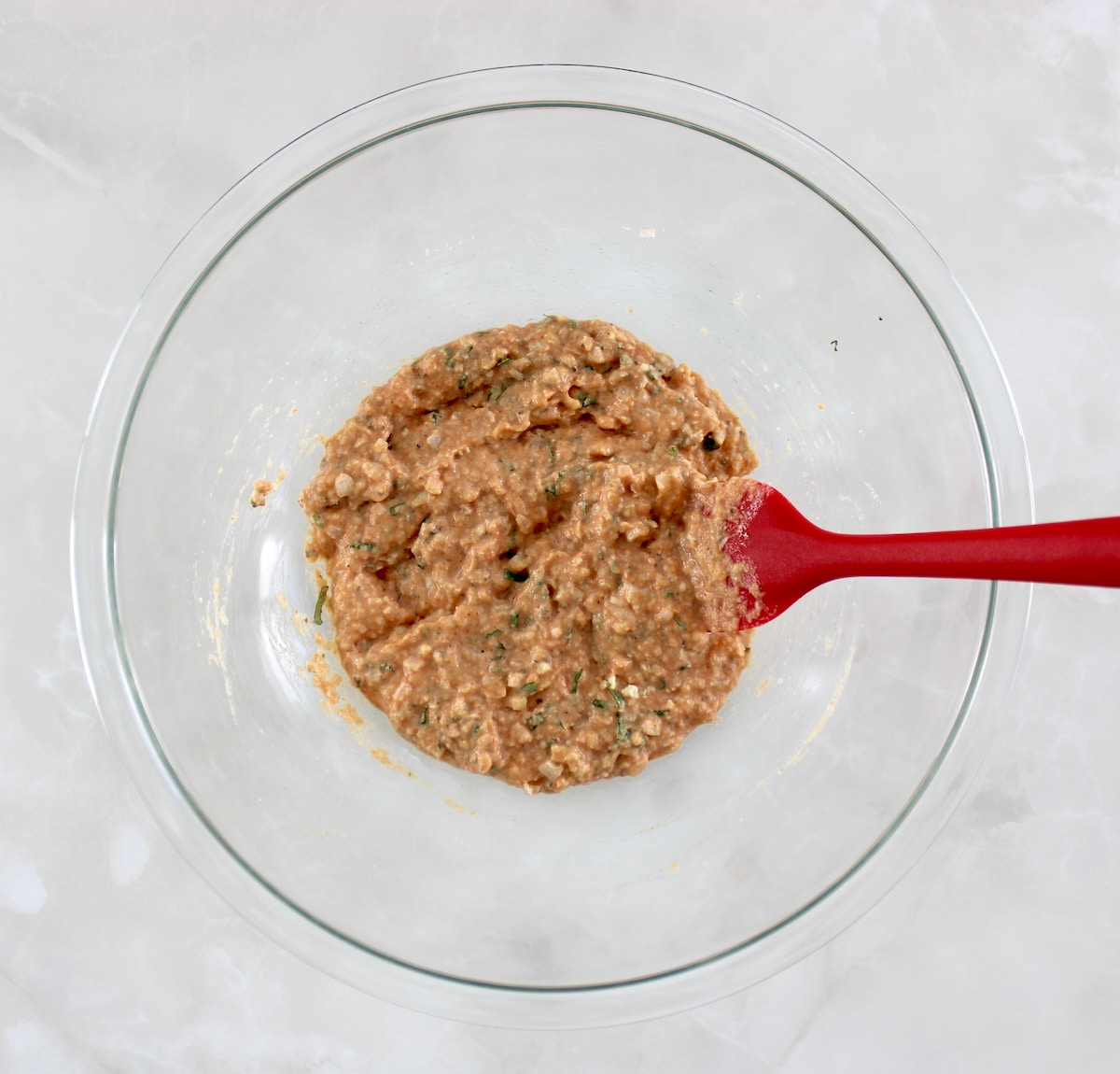 Bacon Wrapped Cheese Stuffed Italian Meatloaf filling ingredients in glass bowl with red spatula