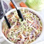 Easy Keto Coleslaw in white bowl with black tongs