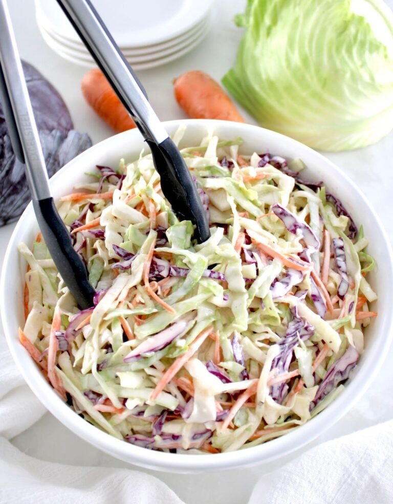 Easy Keto Coleslaw in white bowl with black tongs
