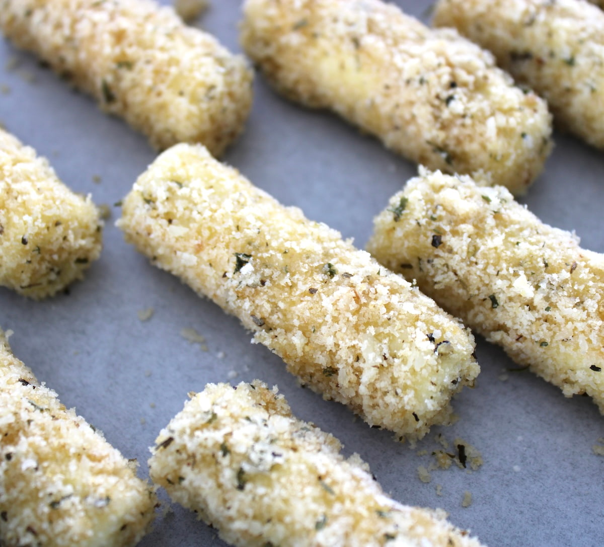 closeup of Keto Mozzarella Sticks unbaked on parchment paper