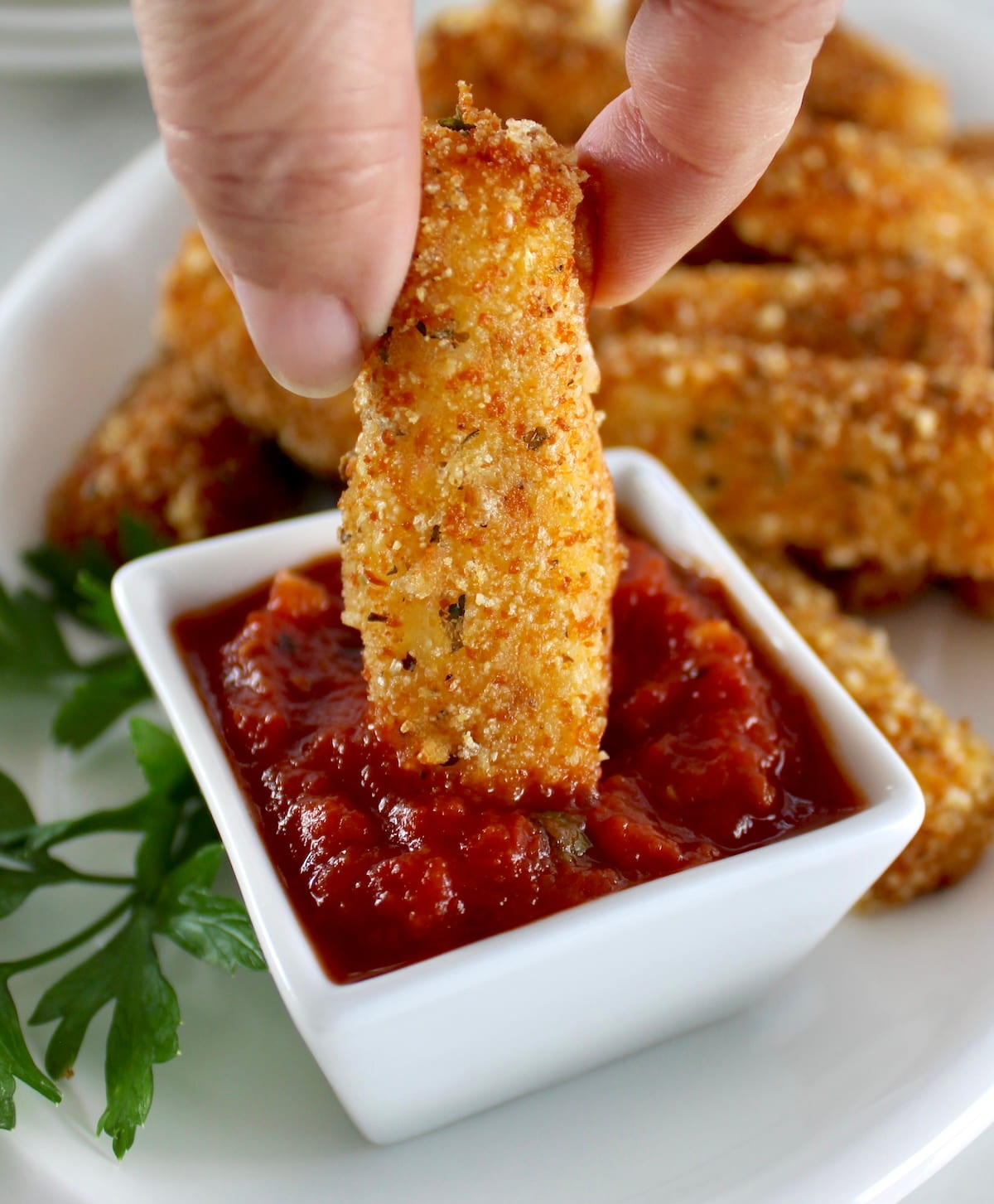 Keto Mozzarella Stick being dipped into marinara sauce