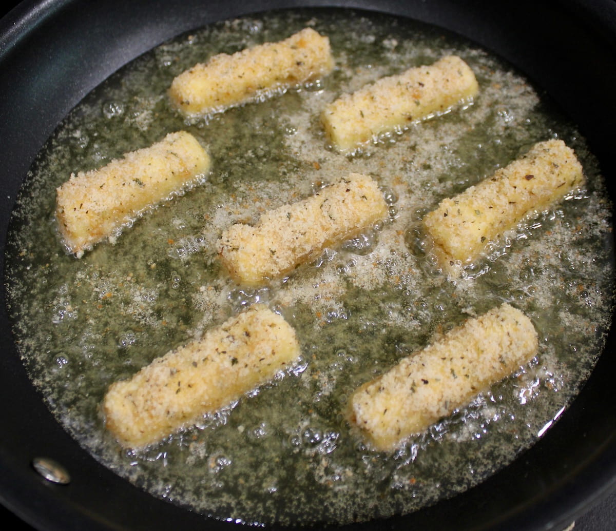 7 Keto Mozzarella Sticks frying in skillet