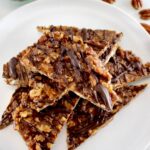 Keto Pecan Praline Bark pieces stacked up on white plate