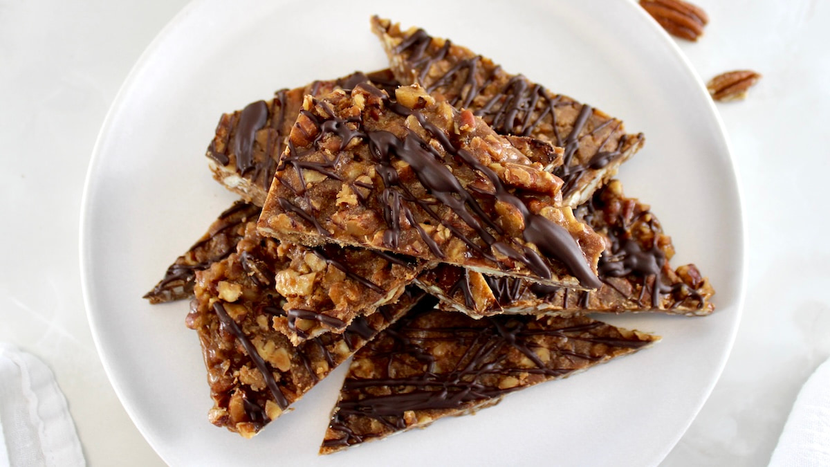 Keto Pecan Praline Bark pieces stacked up on white plate