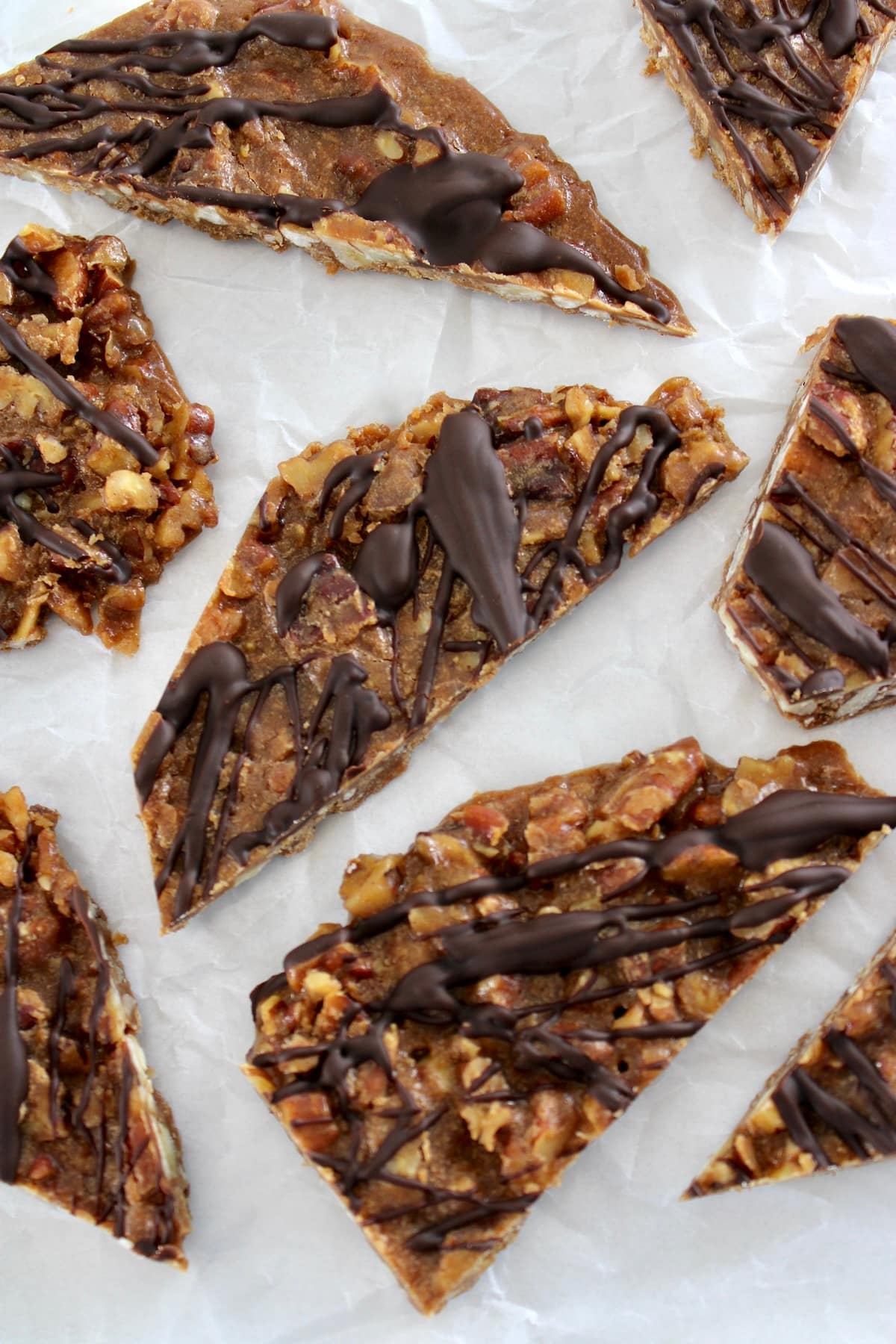 overhead view of pieces of Keto Pecan Praline Bark on white parchment