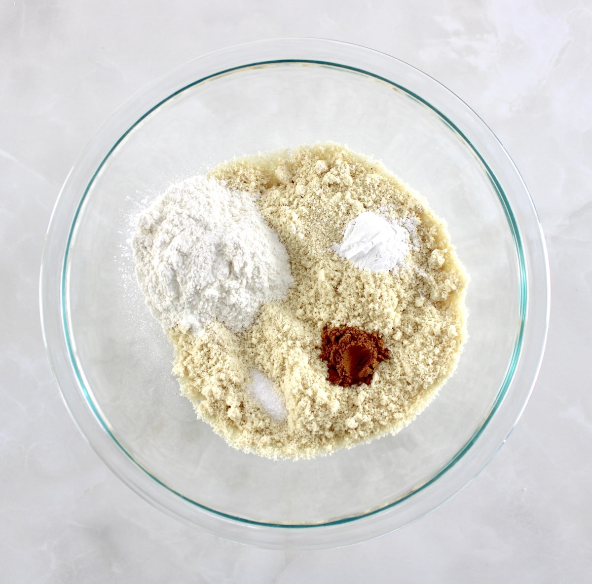 dry ingredients for Keto Pumpkin Cream Cheese Swirl Muffins in glass bowl unmixed