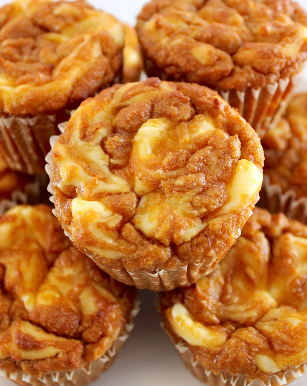 closeup of Keto Pumpkin Cream Cheese Swirl Muffins stacked up