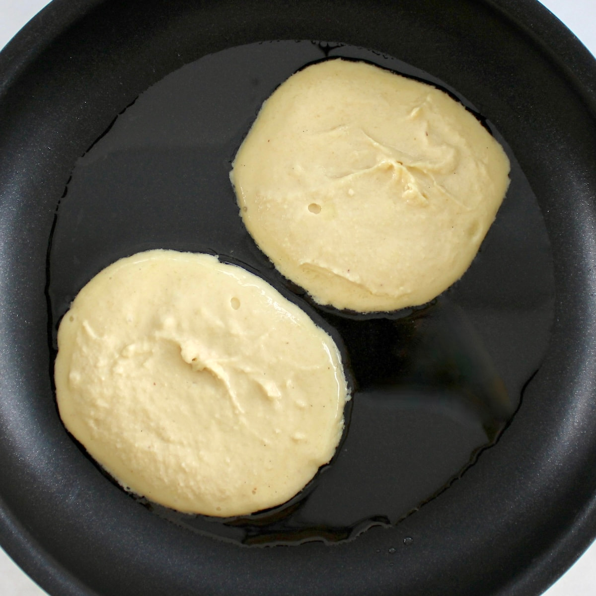 2 Keto Tiramisu Pancakes in skillet uncooked