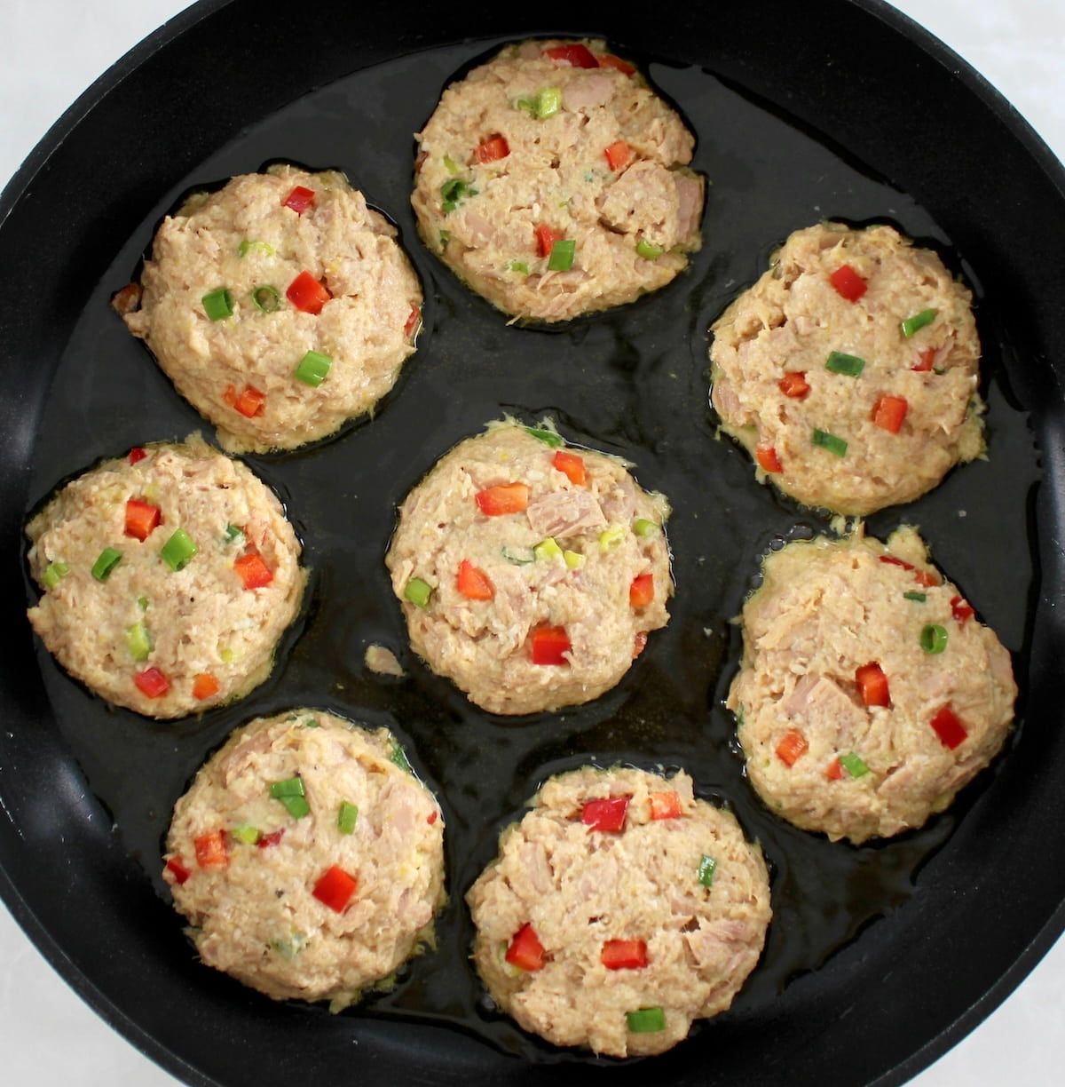 8 raw Tuna Cakes in skillet