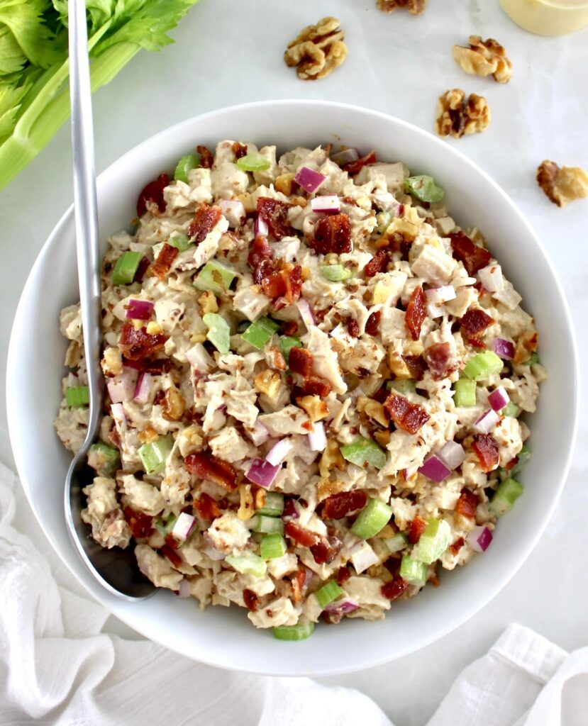 Bacon Honey Mustard Chicken Salad in white bowl with silver serving spoon on side
