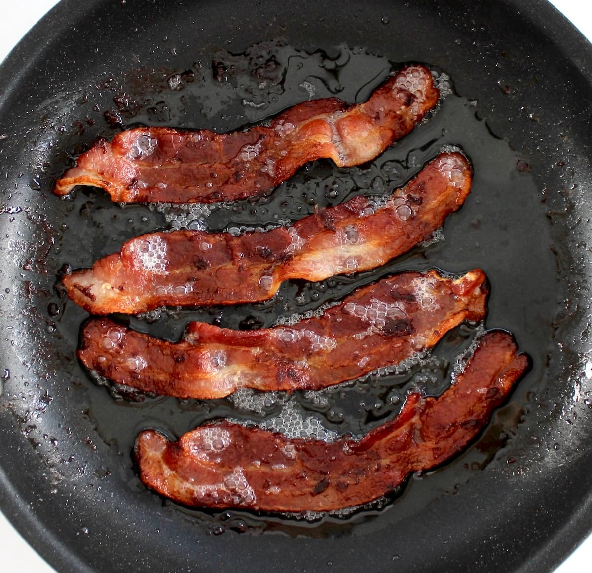 4 slices of crispy bacon in skillet