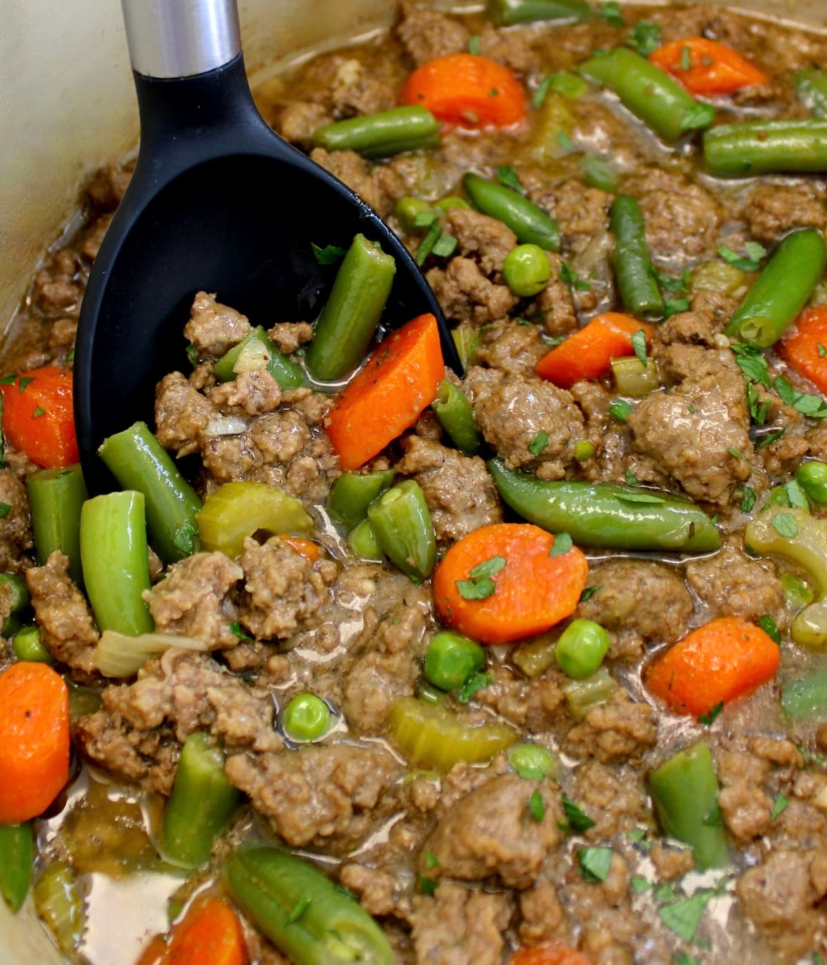 Ground Beef Stew in pot with black serving spoon
