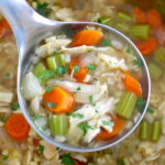 Keto Chicken Soup with Cauliflower Rice in silver ladle held over pot